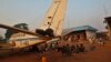 A family displaced by inter-communal violence in the country sit near a plane in a camp for displaced persons at Bangui M'Poko International Airport, Feb. 20, 2014.