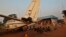 A family displaced by inter-communal violence in the country sit near a plane in a camp for displaced persons at Bangui M'Poko International Airport, Feb. 20, 2014.
