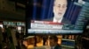 The news conference of Federal Reserve Chairman Ben Bernanke appears on a television screen at a trading post on the floor of the New York Stock Exchange, Dec. 18, 2013.