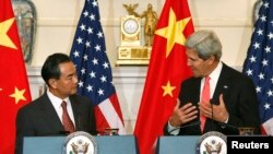 Menlu China Wang Yi (kiri) mendengarkan pernyataan Menlu AS John Kerry sebelum perundingan bilateral keduanya di Kemenlu AS, Washington DC, 19/9/2013.