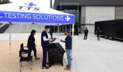 A man checks-in for his COVID-19 vaccine showing QR code on mobile phone in Los Angeles, at a vaccination clinic setup by Los Angeles Football Club, partnering with the LA county Department of Public Health and USC Pharmacy, May 7, 2021.