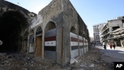 시리아 반군이 홈스 시에서 퇴각하고 있는 가운데, 내전으로 파괴된 상점이 8일 새 문을 단 모습이다. 