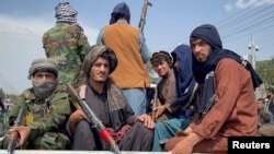 资料照片：塔利班人员在美军撤离阿富汗的一天后在喀布尔国际机场入口处巡逻。(2021年8月31日）