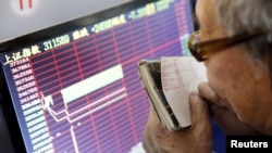 یکی از سهامداران بازار بورس در شانگهای چین در حال بررسی اطلاعات آماری - ۱۷ دی ۱۳۹۴ 