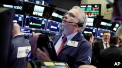 交易员于2018年3月26日在纽约证券交易所工作。美国股市周一早盘大幅上涨