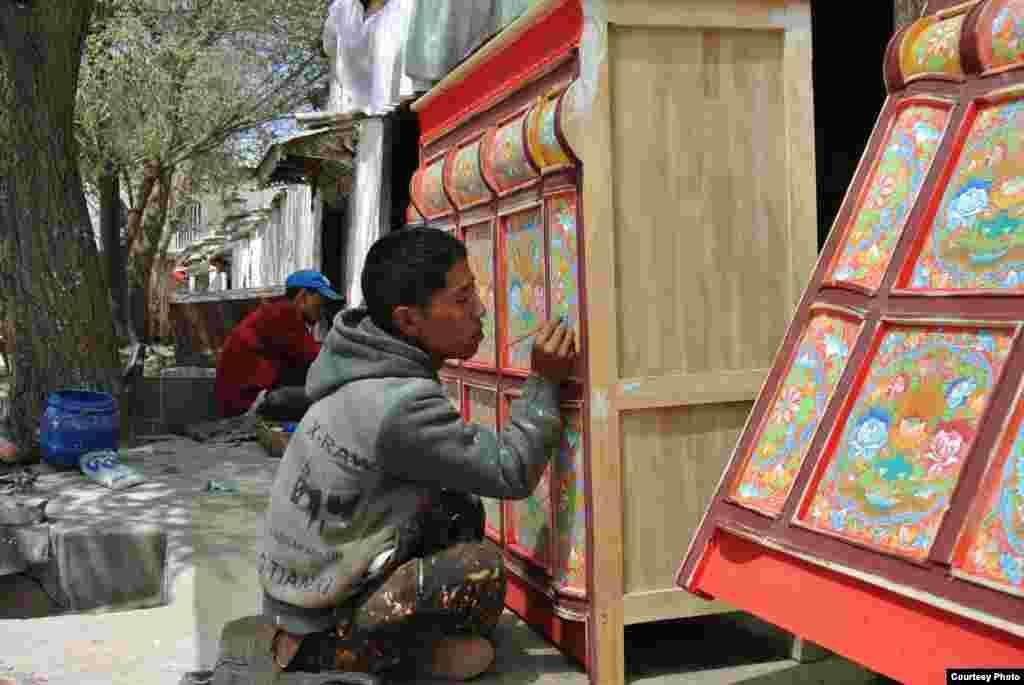 Seorang pekerja menghias sebuah mebel di Karma Gongsong, Lhasa, Tibet. (Foto oleh Tongqi Huang / pembaca VOA)
