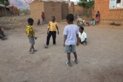 Talandira (in white shirt) plays soccer with friends. (Lameck Masina/VOA)