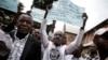 Des Congolais brandissent des pancartes lors d'une manifestation à Kinshasa, le 12 janvier 2018.