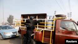 1月9日一名警察在巴格达市一个检查站搜查一辆汽车
