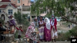 Mana barumsaa Maqalee keessaa namoonni qehee irraa buqahan keessa jiran, Caamsaa 10, 2021.