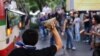 Thai opposition protesters attack a bus carrying pro-government Red Shirt supporters on their way to a rally at a stadium in Bangkok, Nov. 30, 201