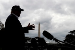 With cloudy skies in Washington, President Donald Trump speaks to the media as he returns to the White House from Camp David, Sunday, Sept. 1, 2019, in Washington.