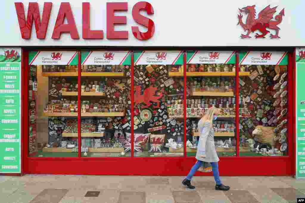 신종 코로나바이러스 감염자 수가 늘어나기 시작한 웨일즈의 수도 카디프에 23일 부터 2주간 봉쇄령이 내려진 가운데 한 여성이 마스크를 쓰고 관광기념품 가계를 지나가고 있다. 
