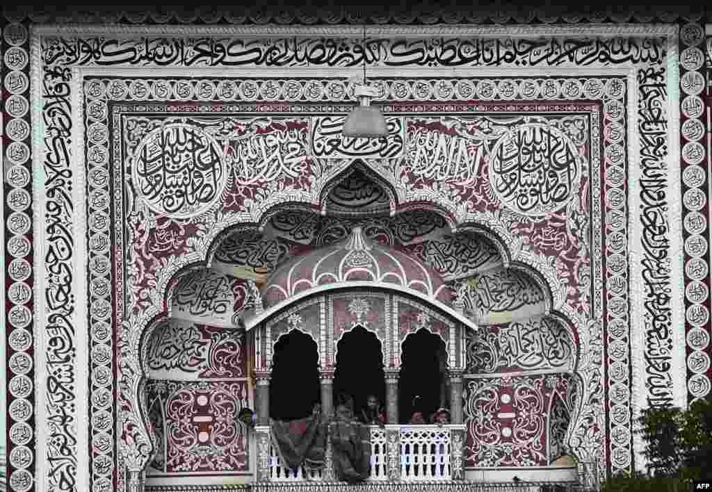 Anak-anak Muslim melongok keluar balkon masjid pada perayaan Idul-Adha di sebuah masjid di Karachi, Pakistan.