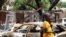 FILE - Two boys stand in front of burnt cars in Michika, a city recaptured from Boko Haram by the Nigeria military. 