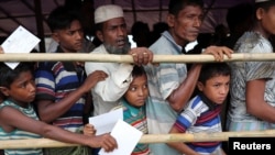 在孟加拉国的难民营，罗兴亚难民等待救济中心发肉。（2018年8月23日）