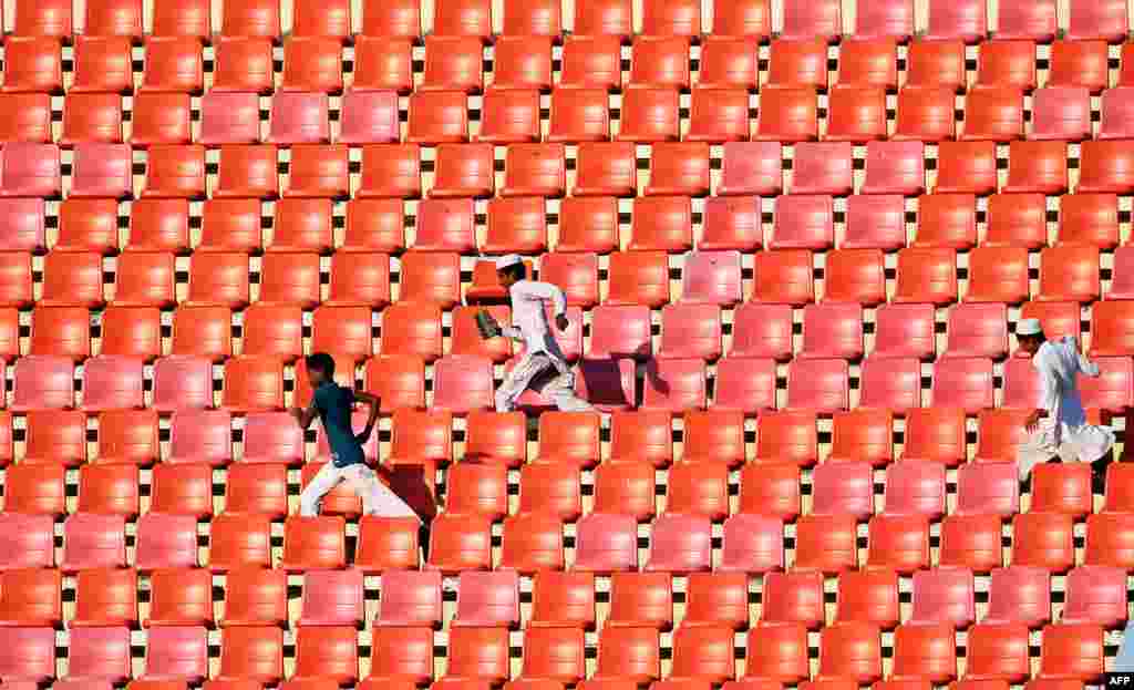 Young Bangladesh cricket fans run between the galleries during the first day of the first Test match between Bangladesh and England at Zahur Ahmed Chowdhury Cricket Stadium in Chittagong.