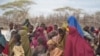 Mothers sit with their children in a compound for internally displaced persons (IDPs) in the Somali border town of Dhobley on August 11, 2011,