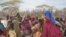 Mothers sit with their children in a compound for internally displaced persons (IDPs) in the Somali border town of Dhobley on August 11, 2011,
