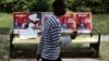 A man passes by posters of presidential candidates Uhuru Kenyatta and Prime Minister Raila Odinga in Nairobi, March 8, 2013. 