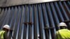 FILE - Construction workers check a new section of bollard wall in Santa Teresa, N.M., as seen from the Mexican side of the border, April 23, 2018, on the outskirts of Ciudad Juarez, Mexico.