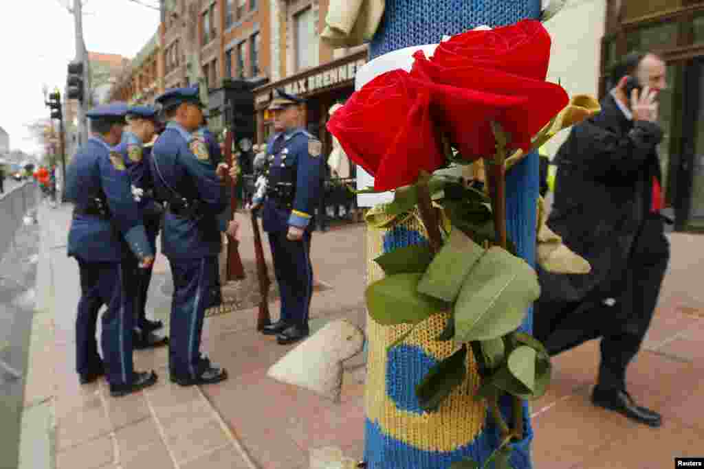 Bunga mawar dipasang di tiang lampu jalanan dekat lokasi meledaknya bom kedua sebagai bagian peringatan setahun pemboman Maraton Boston di Massachusetts (15/4). (Reuters/Brian Snyder)