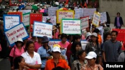 Female workers hold signs as they gather to mark International Women's Day outside the United Nations building in Bangkok, (File photo).
