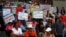 Female workers hold signs as they gather to mark International Women's Day outside the United Nations building in Bangkok, (File photo).