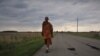 Buddhist monk Sutham Nateetong walks along the road outside Arcola, IN. June 8, 2019.