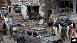 Para petugas keamanan Pakistan dan tim SAR memeriksa lokasi ledakan bom mobil di Peshawar, Pakistan (30/6). Korban rangkaian serangan di berbagai wilayah Pakistan meningkat menjadi 52 orang, Senin (1/7).