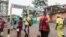 FILE - People, some wearing masks, walk by the entrance to Yaounde General Hospital, in Yaounde, Cameroon, March 6, 2020, amid the coronavirus pandemic. 