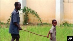 FILE - A child leads a man affected by river blindness in Gbarnga, Liberia, Sept. 4, 1995. Hospitals in Cameroon are reporting an increase in cases of the disease in 2023, which is caused by bites from infected blackflies. 