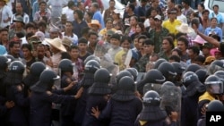 In this photo taken on Sept. 5, 2013, rubber farmers confront and scuffle with Thai anti-riot police officers on a highway in Prachuab Khirikhan province, southern Thailand.