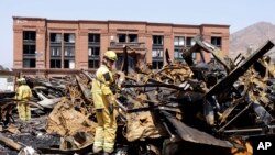 Los Angeles County firefighter Darrick Woolever examines metal that needs to be removed after a fire, June 2, 2008, at the Universal Studios Hollywood back lot.