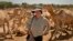 Mary F. Calvert with a camel herd in Ethiopia, where she was documenting drought conditions, Feb. 16, 2006. (Photo by Betsy Pisik/The Washington Times)