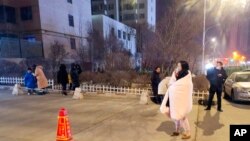 中国青海省西宁市的居民地震发生后站在街头观望（2022年1月8日）