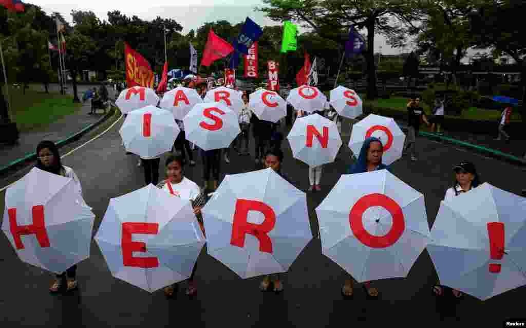 Para pengunjuk rasa membawa tulisan &quot;Marcos is no Hero&quot; (Marcos Bukan Pahlawan) ketika memrotes rencana pemindahan jenazah mantan diktator Ferdinand Marcos ke taman makan pahlawan di Manila, Filipina.