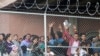 FILE - In this March 27, 2019, photo, Central American migrants wait for food in a pen erected by U.S. Customs and Border Protection to process a surge of migrant families and unaccompanied minors in El Paso, Texas. 