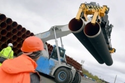 FILE - Steel pipes for the North Stream 2 pipeline are uploaded in Mukran port in Sassnitz, Germany, May 8, 2017.