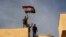 Iraq's elite counterterrorism force soldiers raise an Iraqi flag over the main church in Bartella, Iraq, Oct. 21, 2016.