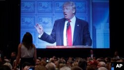 도널드 트럼프 공화당 대통령 후보가 8일 디트로이트 이코노믹 클럽에서 경제정책 구상을 밝히는 동안 한 청중이 자리에서 일어나 소리치고 있다.