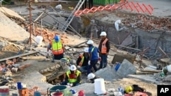 የአደጋ ጊዜ ሠራተኞች ከተደረመሰው ሕንፃ ሥፍራ በሥራ ላይ ጆርጅ፣ ደቡብ አፍሪካ 