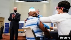 美国总统拜登在弗吉尼亚神学院设立的新冠疫苗接种站为接种疫苗的民众鼓掌。(2021年4月6日)