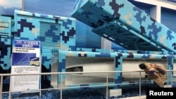 一名参观者在广东珠海航空展上观看新型地对舰CM-401导弹系统。（2018年11月8日）