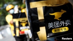 北京金融区的一个美团外送小哥骑着电摩在外送。