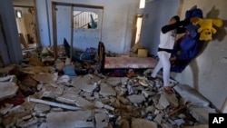 Seorang pria mengambil barang-barang yang tertinggal dari rumah Hamza Abu el-Heija, yang tewas terbunuh saat Militer Israel menyerang kamp pengungsi di Jenin, Tepi Barat (22/3).