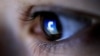 FILE - A picture illustration shows a Facebook logo reflected in a person's eye.