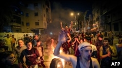 Palestinians parade a burning tyre as they shout slogans in support of the Al-Aqsa Mosque during a rally in Gaza city on April 24, 2021, condemning overnight clashes in Israeli-annexed east Jerusalem. 