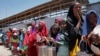 FILE - In this photo taken Feb. 25, 2017, displaced Somali girls who fled the drought in southern Somalia stand in a queue to receive food handouts at a feeding center in a camp in Mogadishu, Somalia.