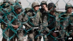2013年3月21日，韩国士兵在非军事区附近演习时走过一道铁丝网。
